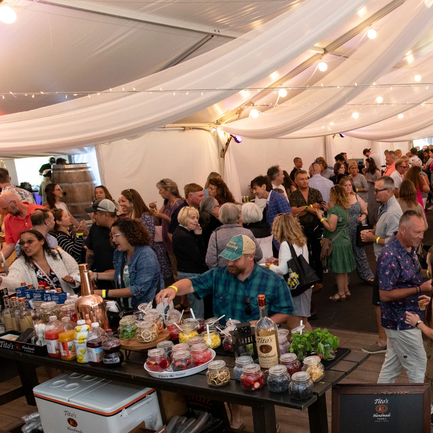 Image from the 2023 Best of NH party, crowd under a tent enjoy food and drinks.